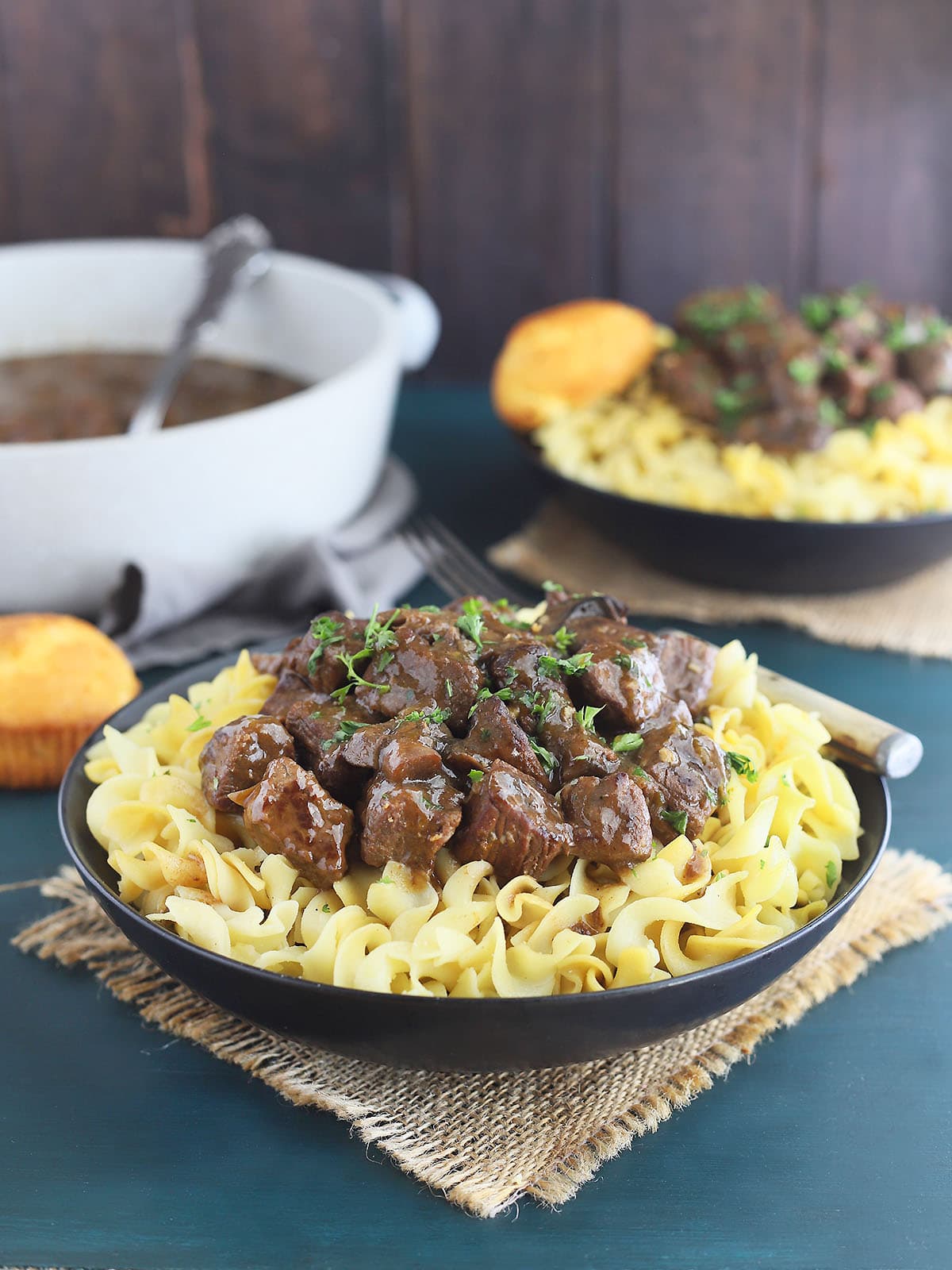 A bowl of of braised beef tips over egg noodles.