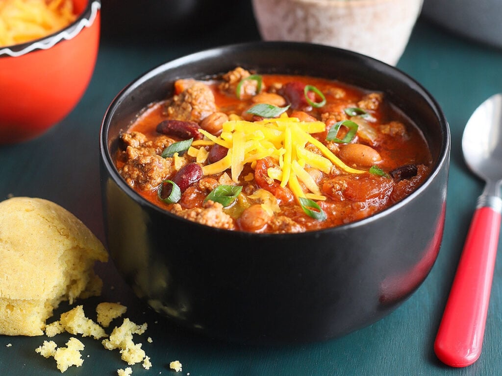Bowl of Cowboy Chili topped with shredded cheese.