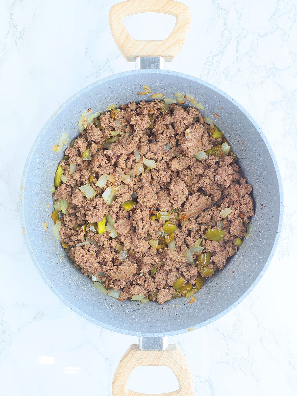 Browned ground beef, onions and green bell pepper in a large stock pot.