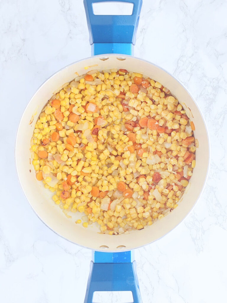 Sauteed carrots, onions, corn and garlic in a large stock pot.