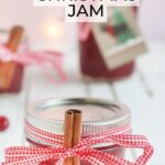 Jars of Christmas Jam garnished with red ribbon and cinnamon stick.