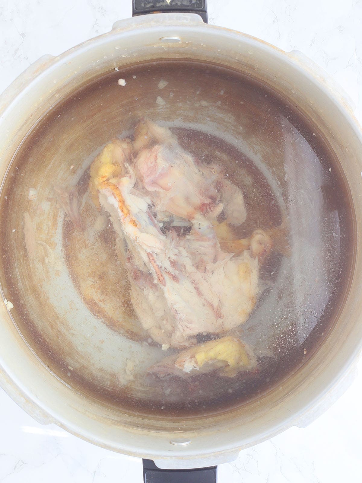 Chicken carcass after water has been poured over the top.