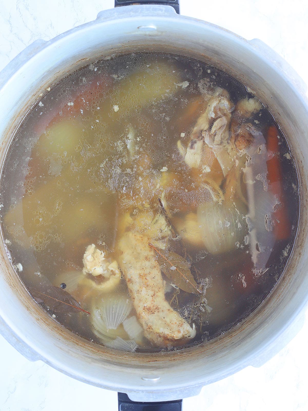 Homemade chicken stock after it has simmered for several hours.