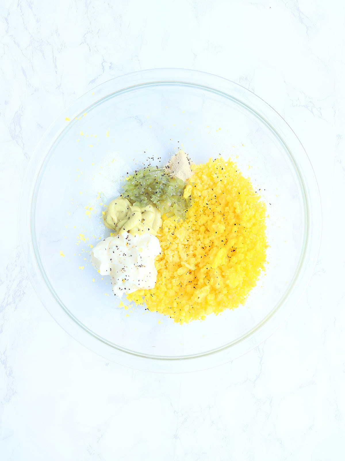 Deviled egg ingredients in a mixing bowl before they have been mixed together.