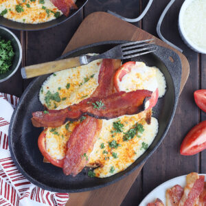 Kentucky Hot Brown sandwich on a cast iron tray with a fork on the side.