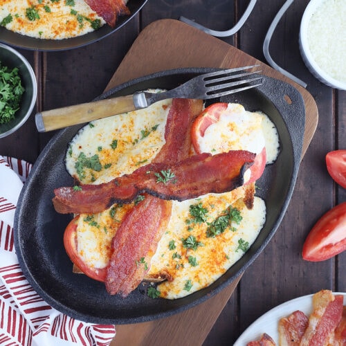 Kentucky Hot Brown sandwich on a cast iron tray with a fork on the side.