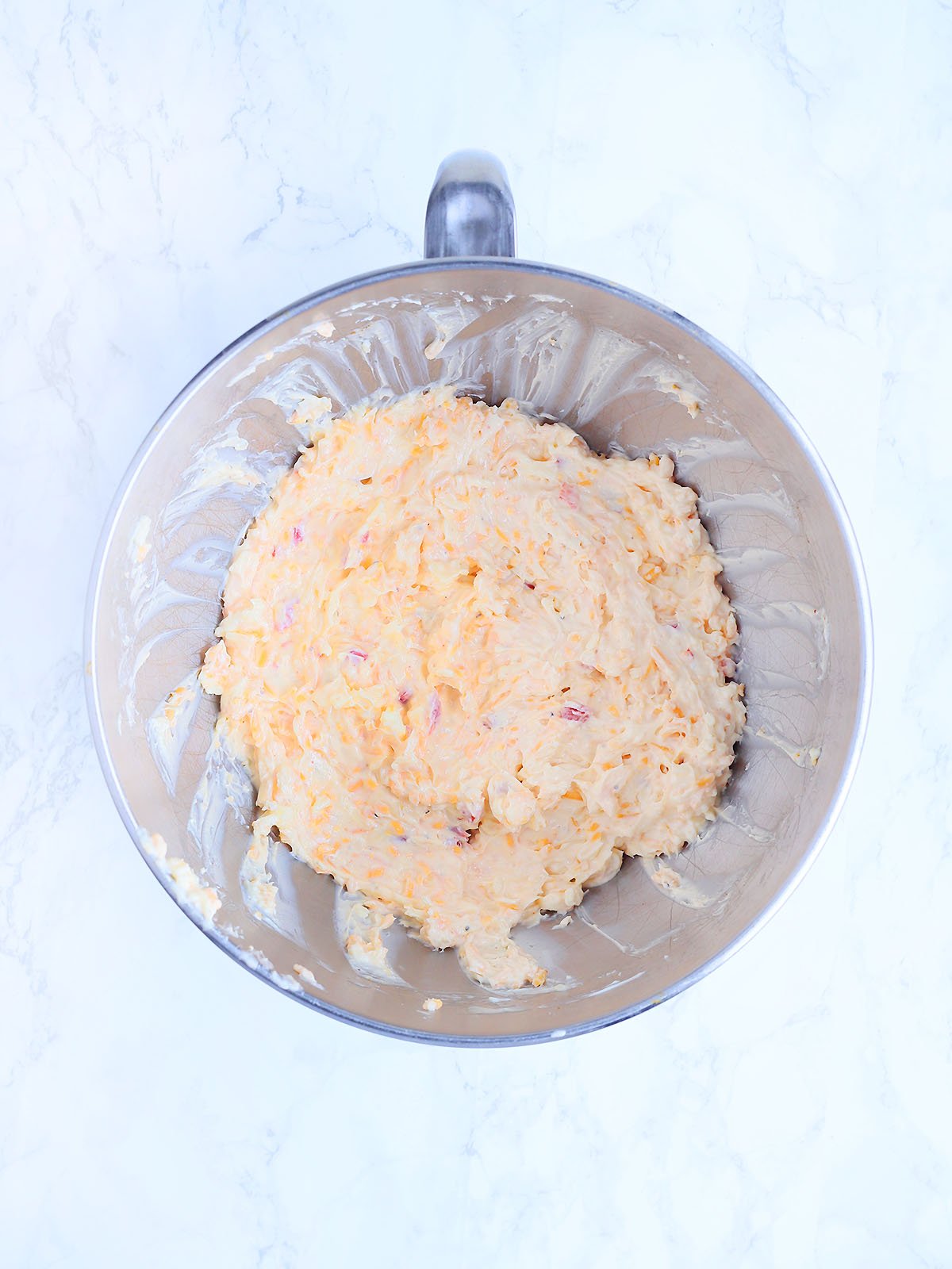 Mixed pimento cheese in a stainless steel mixing bowl.