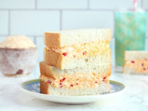 Halved Masters pimento cheese sandwich stacked on a plate.