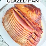 Sliced ham with Coca-Cola glaze on a white serving platter.
