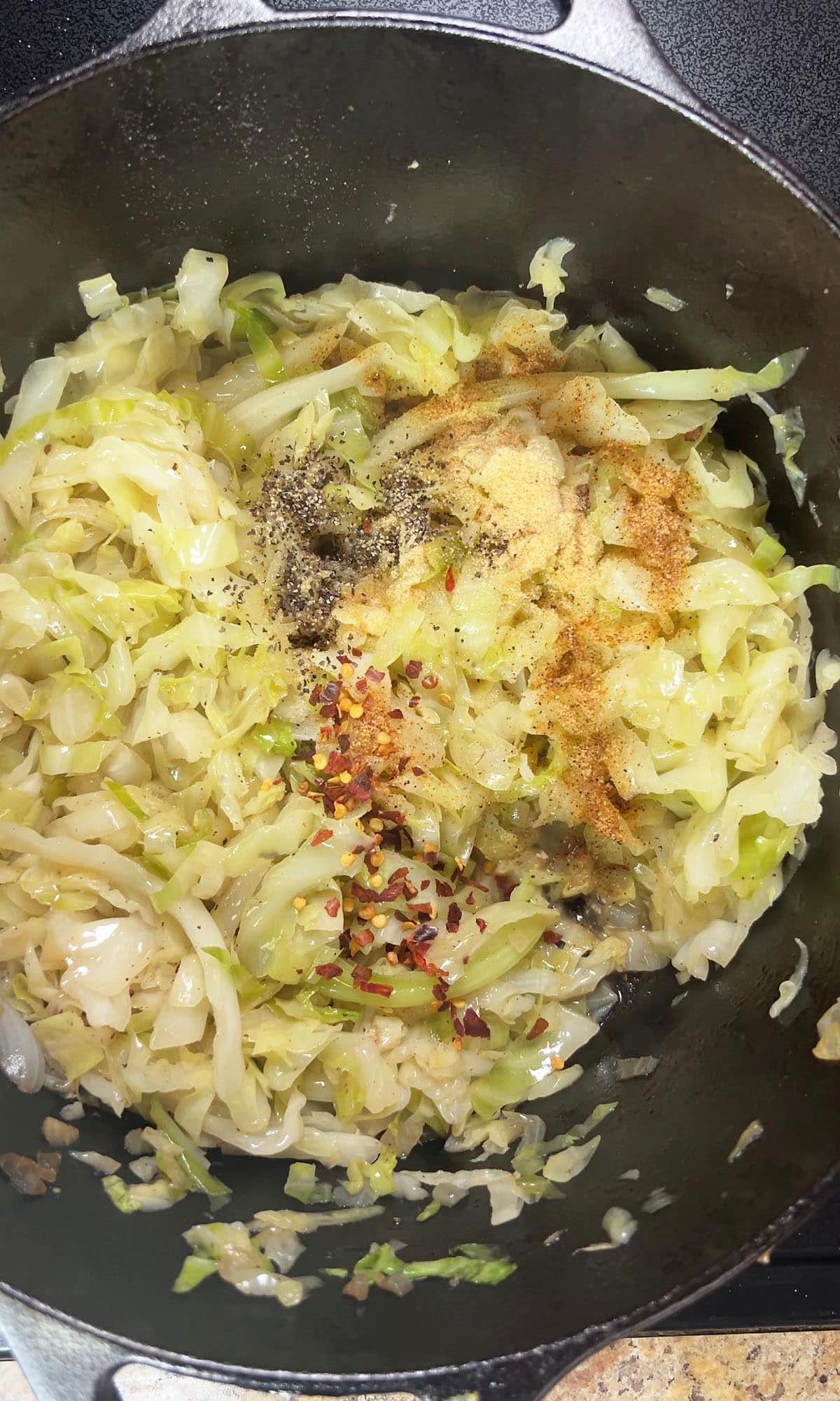 Cabbage and smoked sausage after the spices and apple cider vinegar have been added.