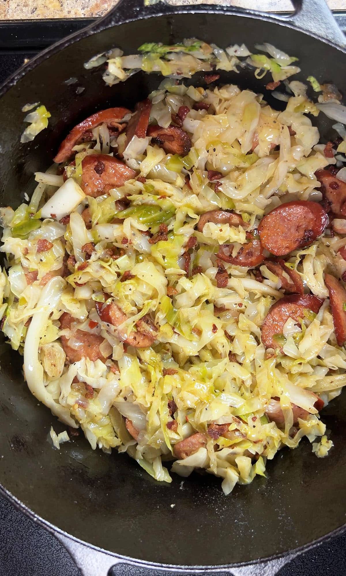 Completed cabbage and smoked sausage in a large Dutch oven.
