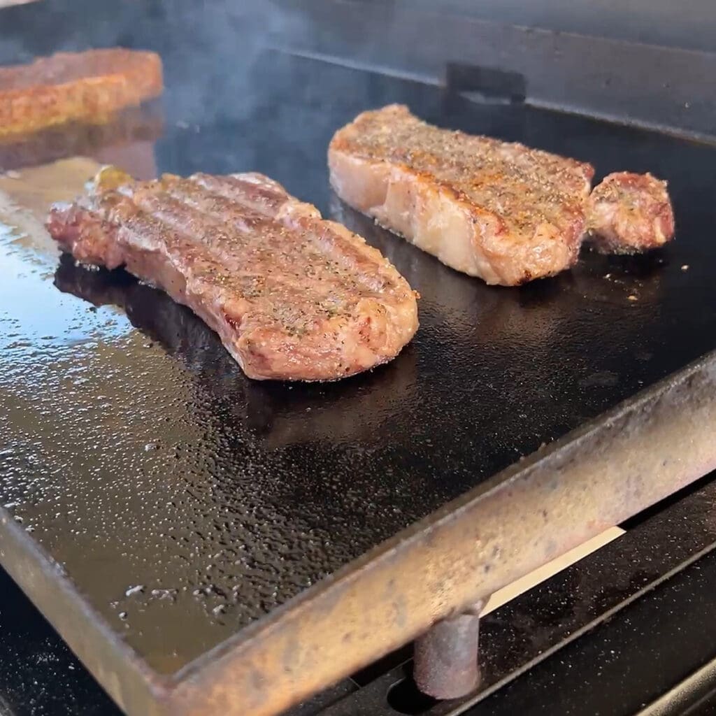 Reverse searing the steaks on a Blackstone outdoor griddle.