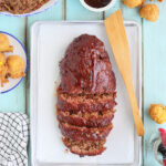 Sliced meatloaf on a parchment paper-lined tray.