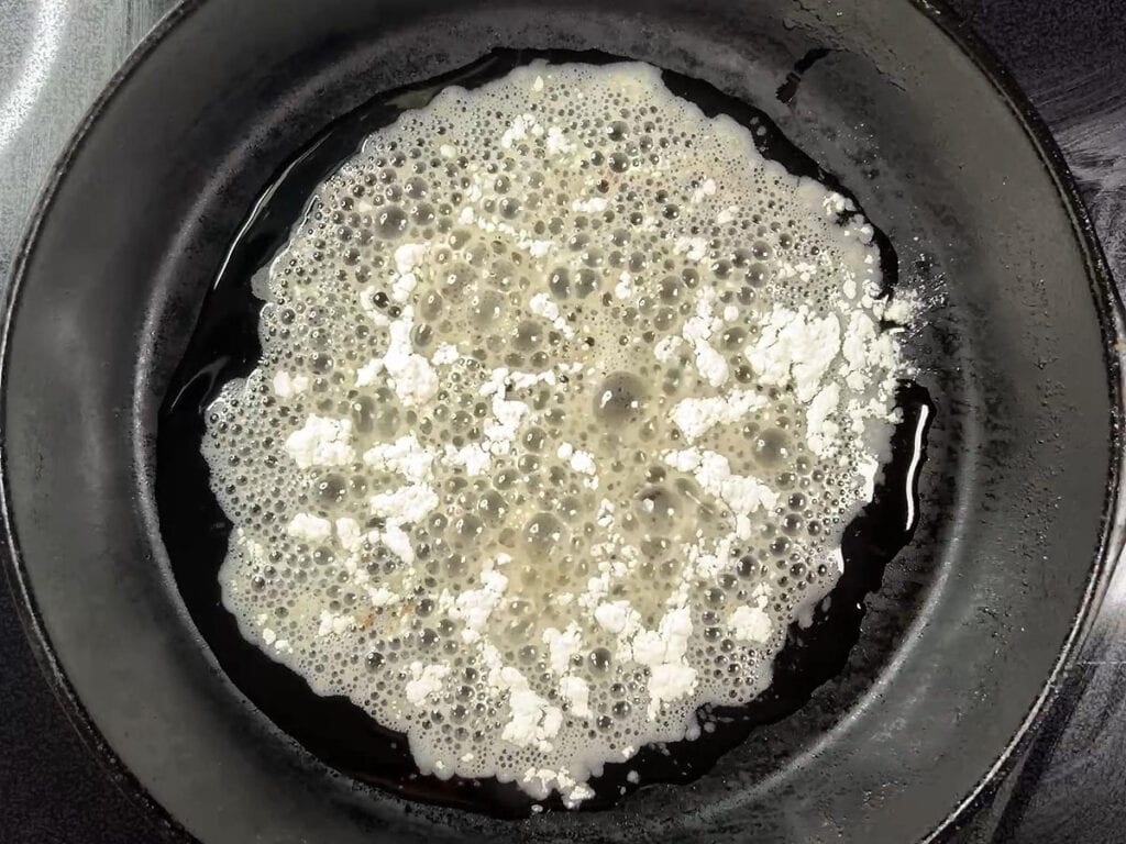 Flour that has been added to hot oil in a cast iron skillet.