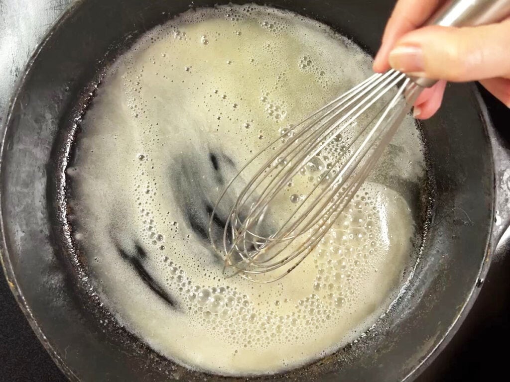 Whisking flour into the hot oil.