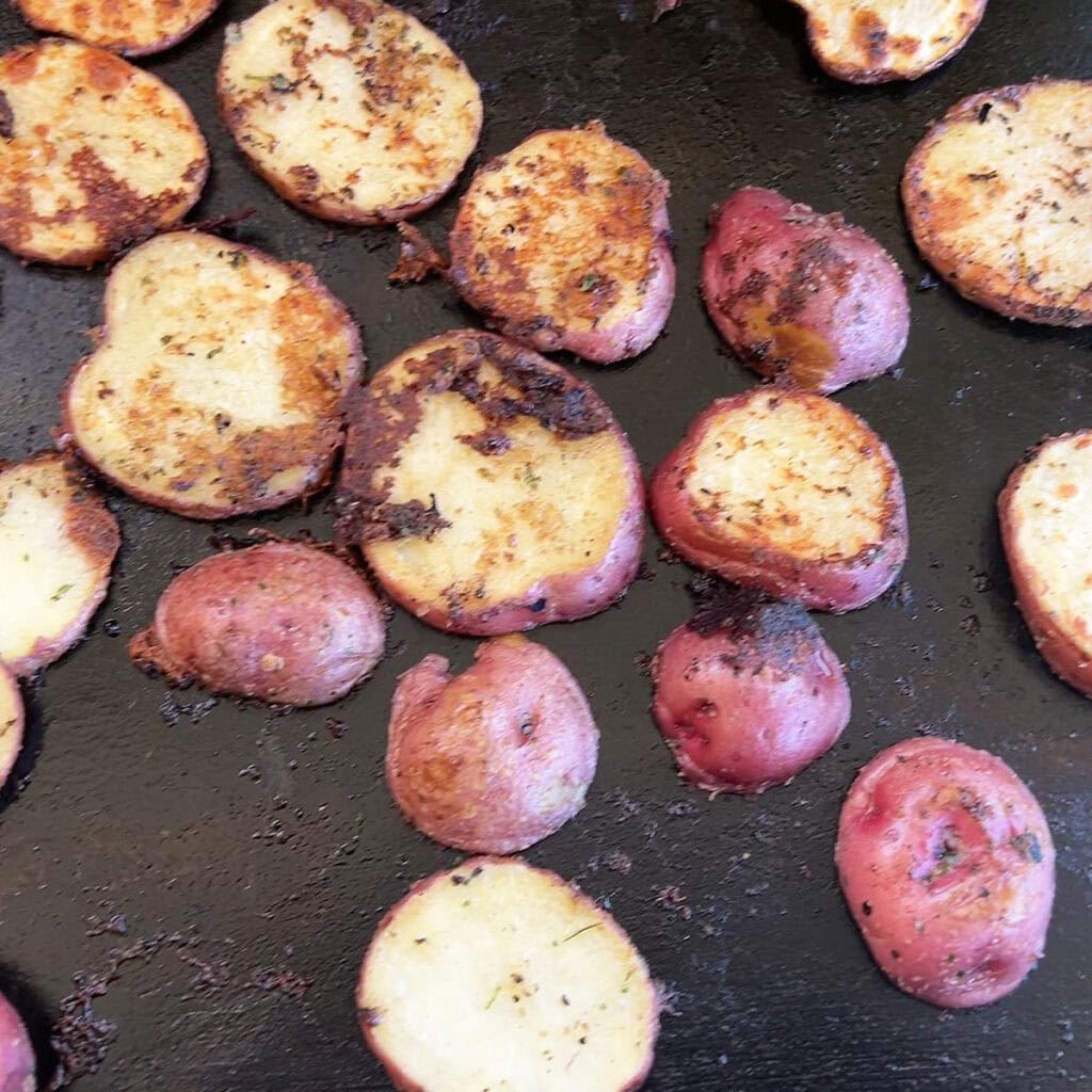 Browned potatoes on the griddle.