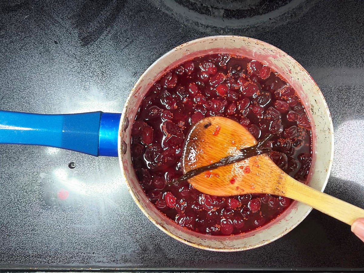 Removing the vanilla bean pod from the saucepan.