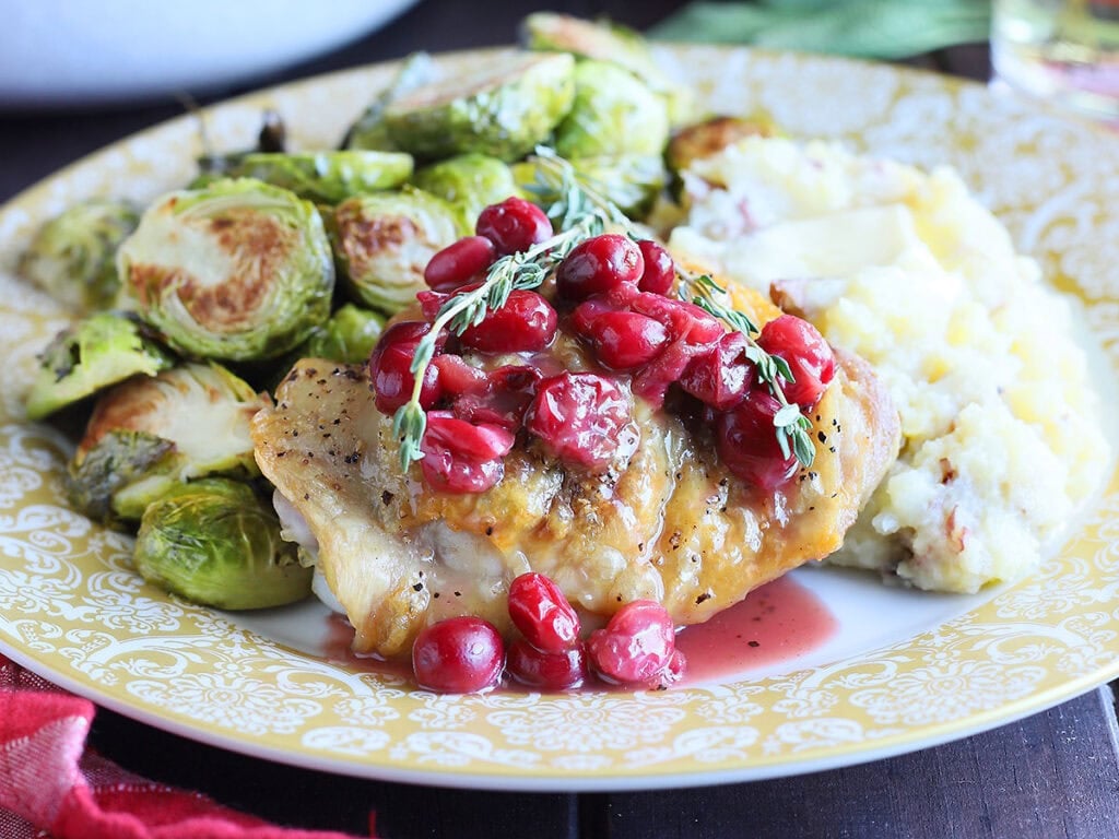 Single serving of cranberry chicken with mashed potatoes and roasted Brussels sprouts.