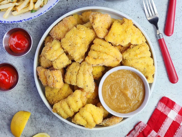 Platter of catfish nuggets with champagne dipping sauce on the side served with French fries and cole slaw.