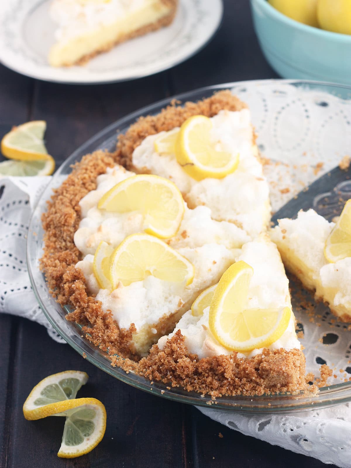 Sliced lemon icebox pie garnished with fresh lemon slices.