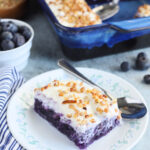 One slice of blueberry jello salad on a floral plate with a spoon.