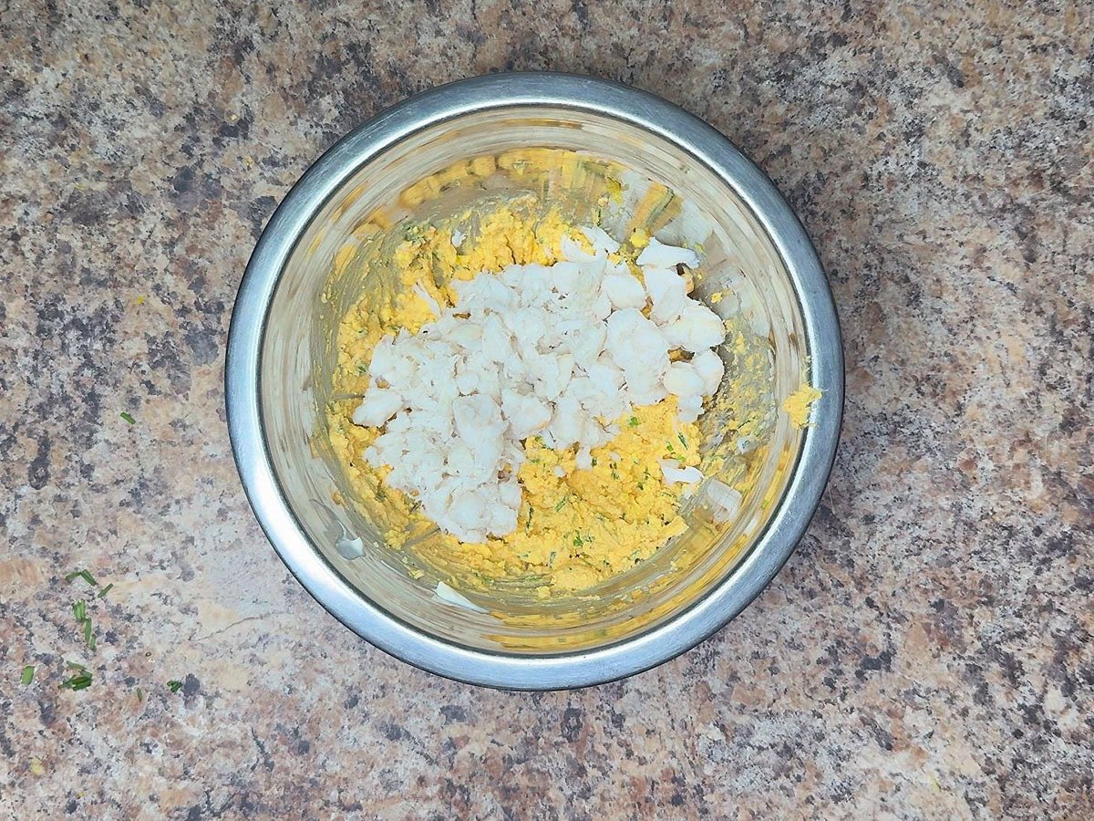 Adding the crab meat to the egg filling.