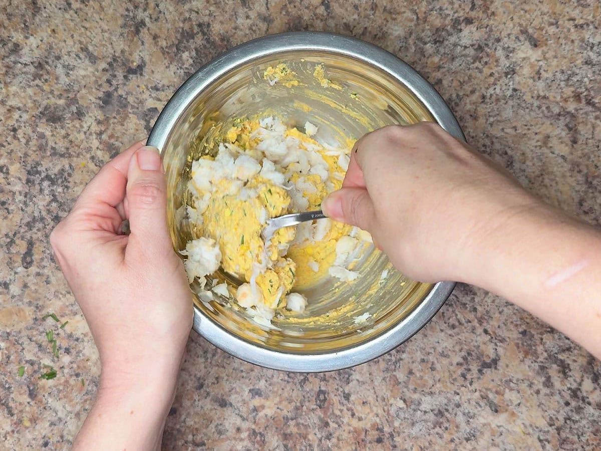 Folding the crab meat into the egg filling.