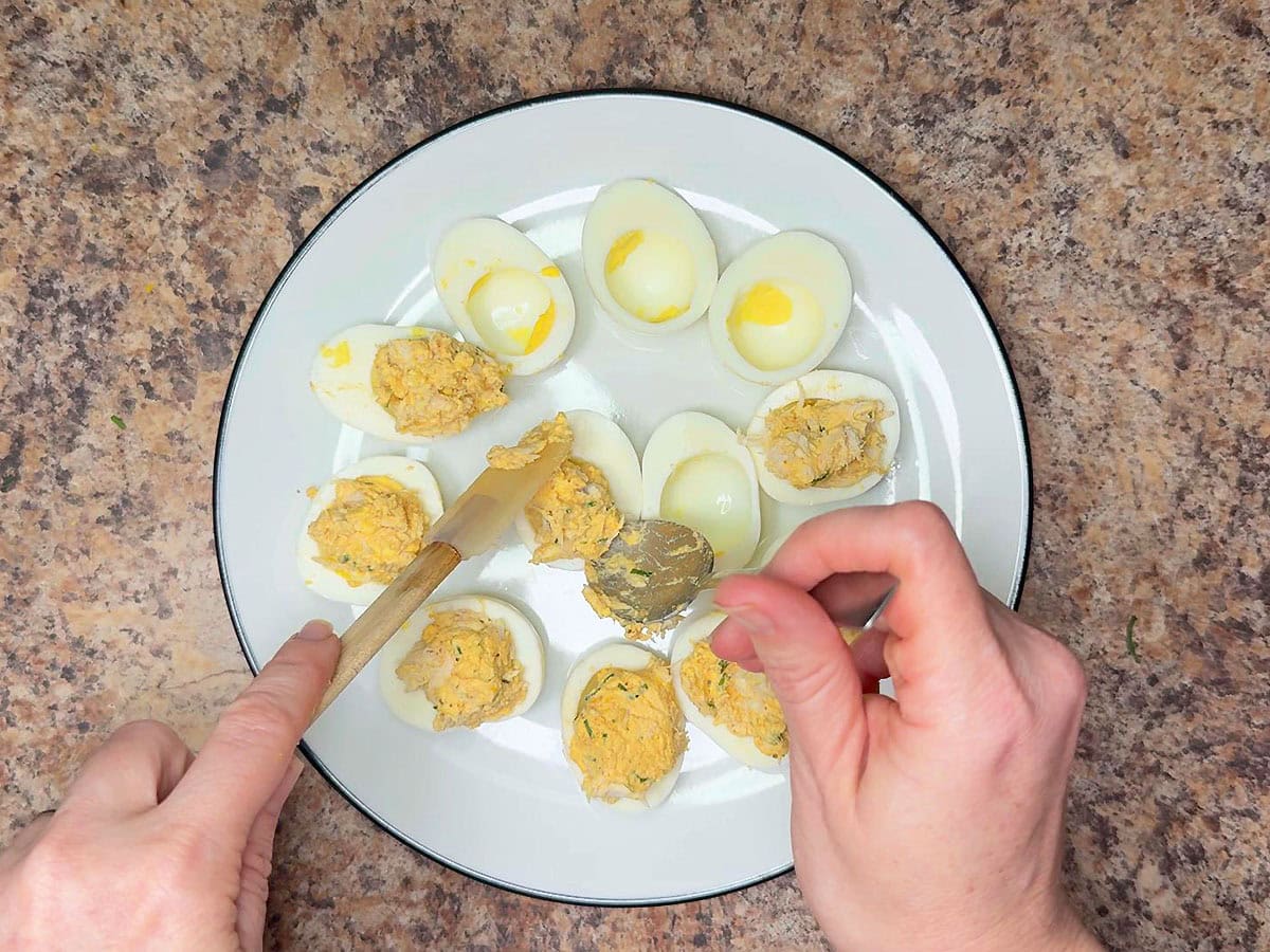 Filling the egg whites with the crab and egg mixture.