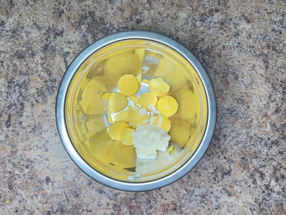 Egg yolks and mayonnaise in a medium mixing bowl.