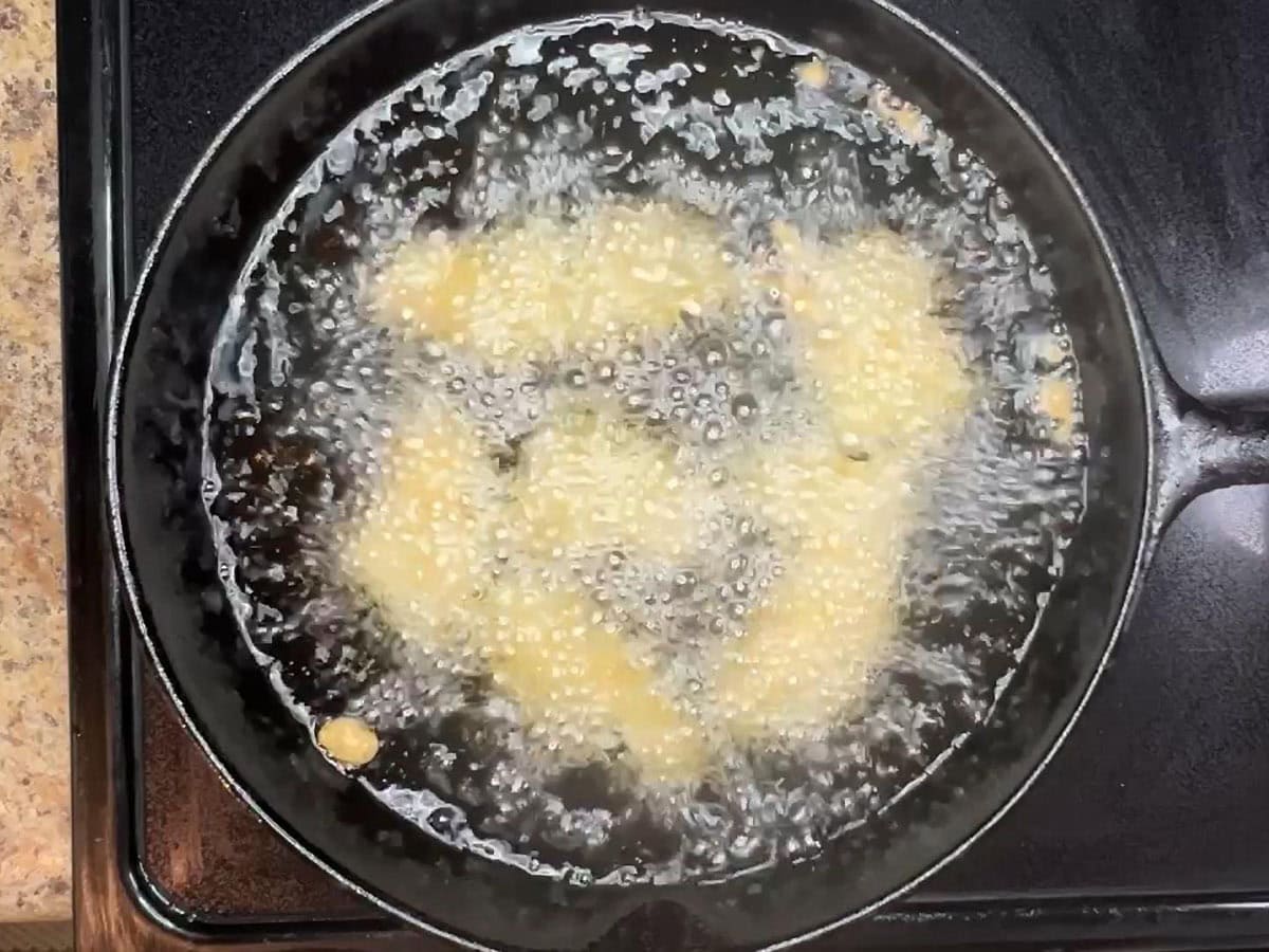 Beer battered catfish frying in hot oil.