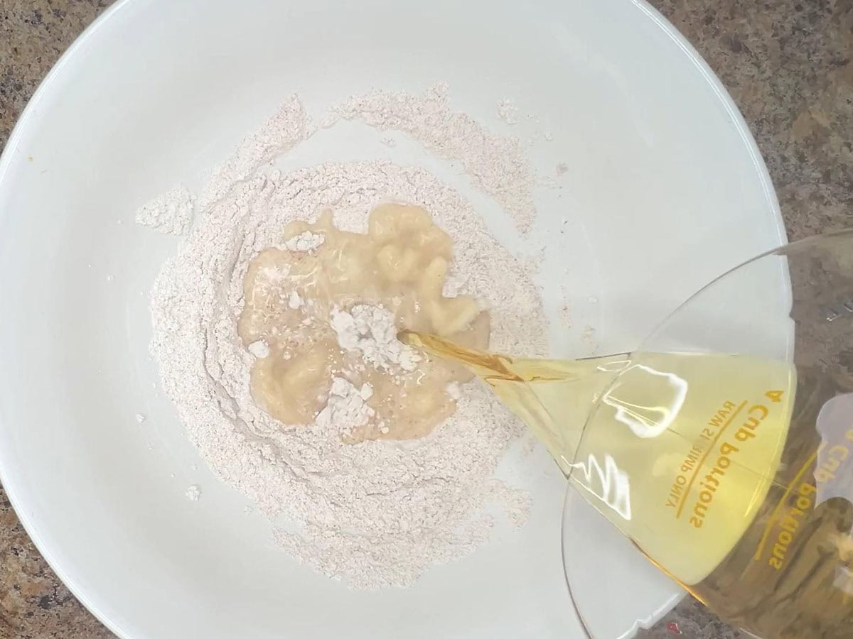 Adding one cup of beer to the seasoned flour.