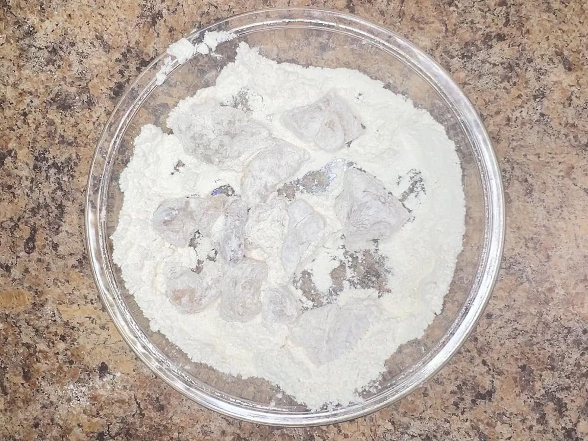 Coating catfish pieces in flour.