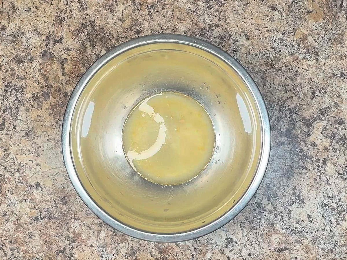 Liquid strained from the can of salmon in a large mixing bowl.