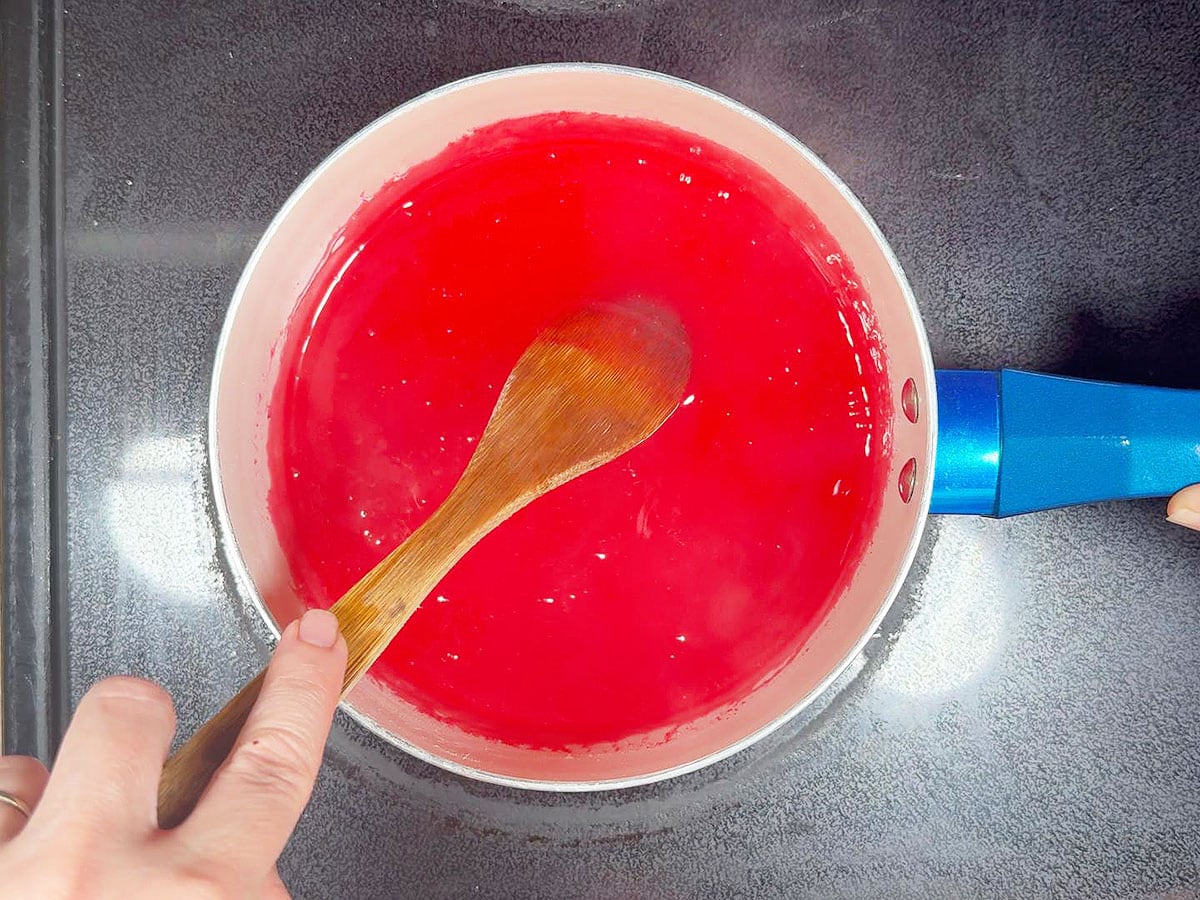 Dissolving the strawberry gelatin into the base mixture.