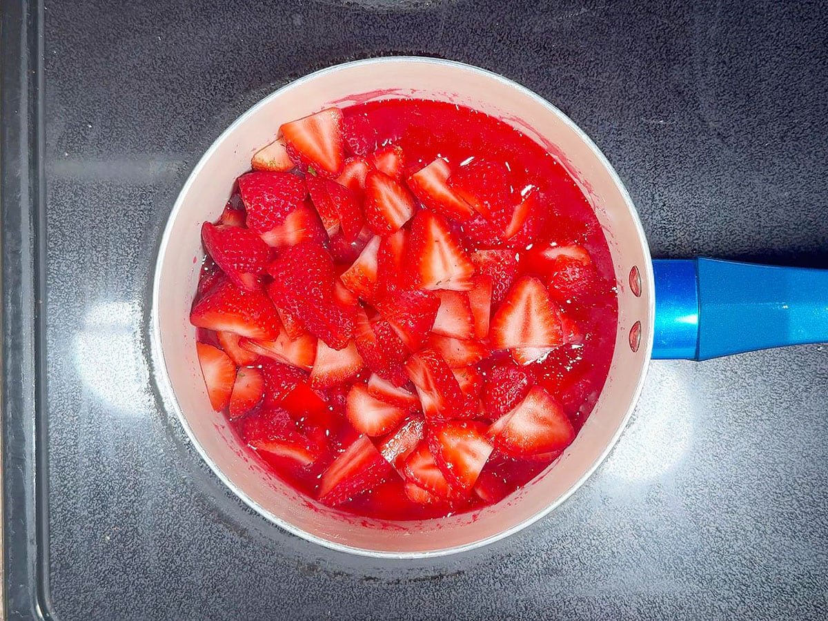 Adding the strawberries to the gelatin mixture.