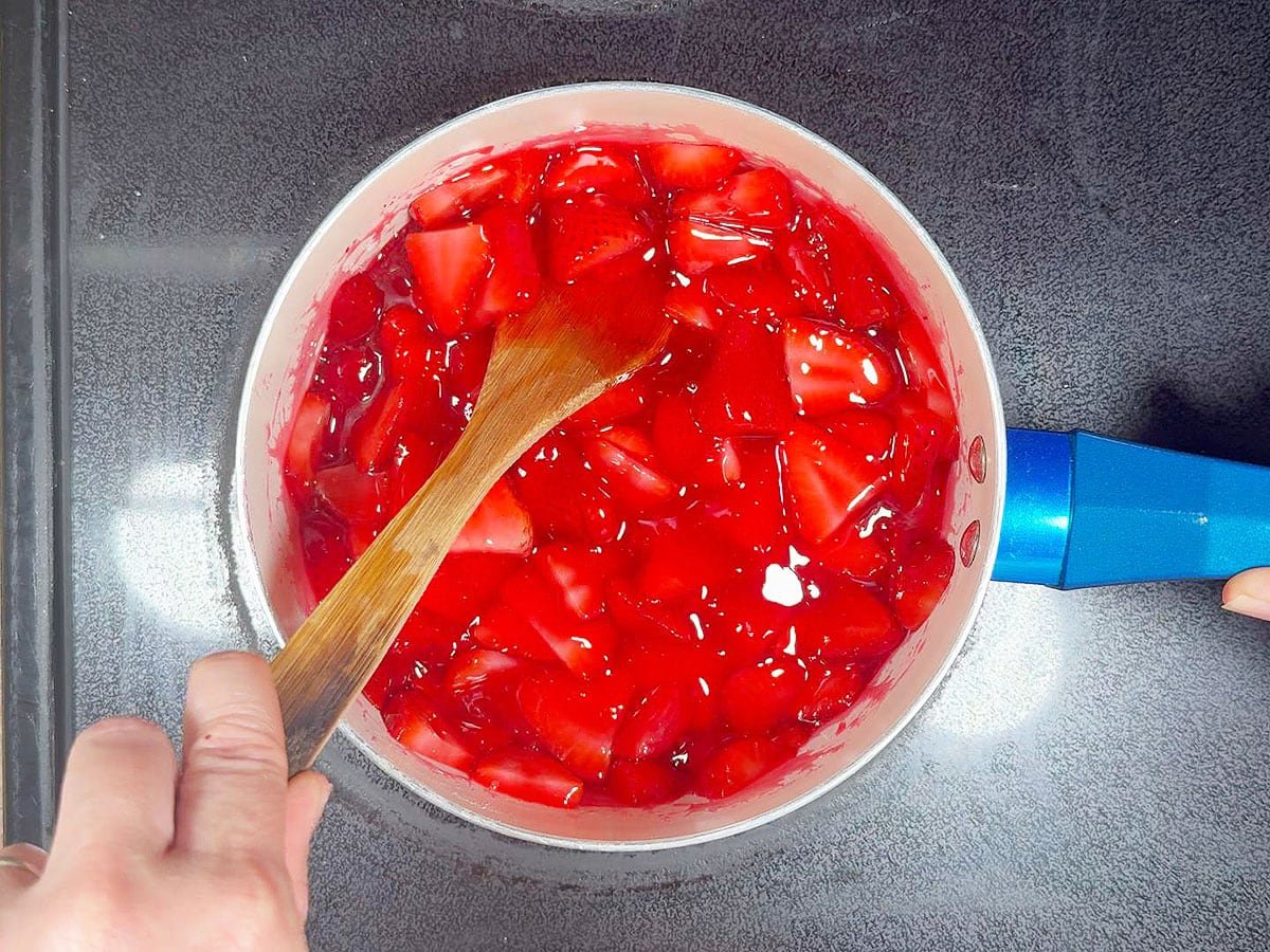 Strirring the strawberries into the gelatin mixture.