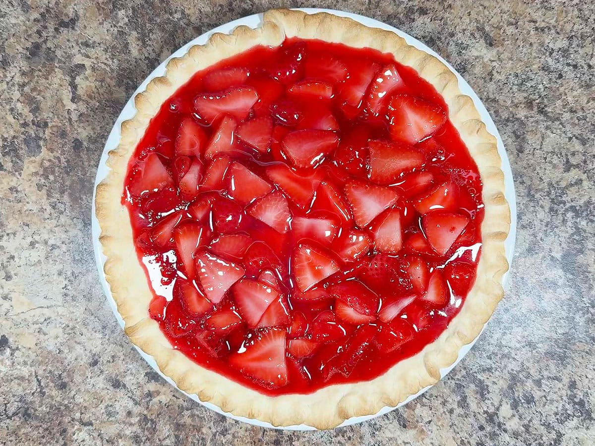 Strawberry pie filling after it has been poured in a baked pie crust.