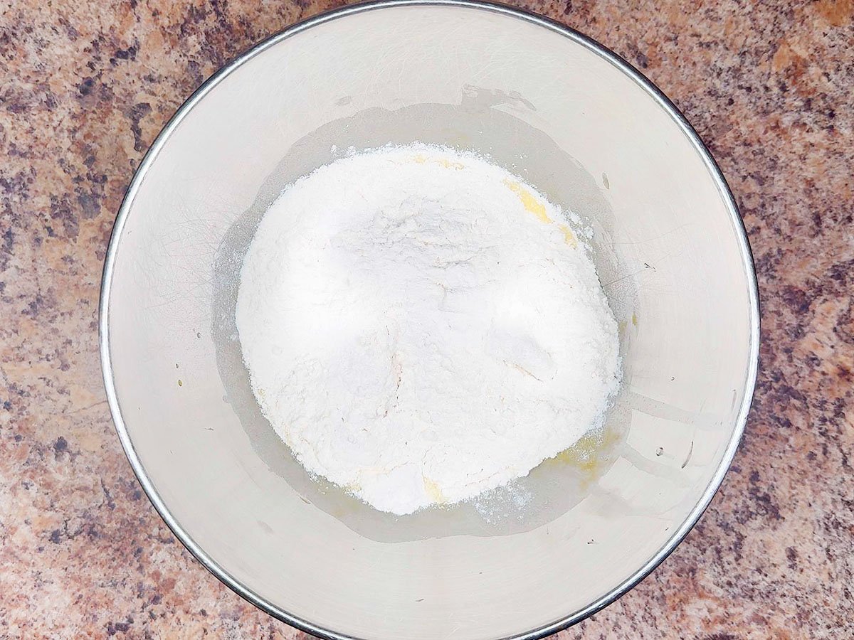 White cake mix added to the lightly beaten eggs in a large mixing bowl.