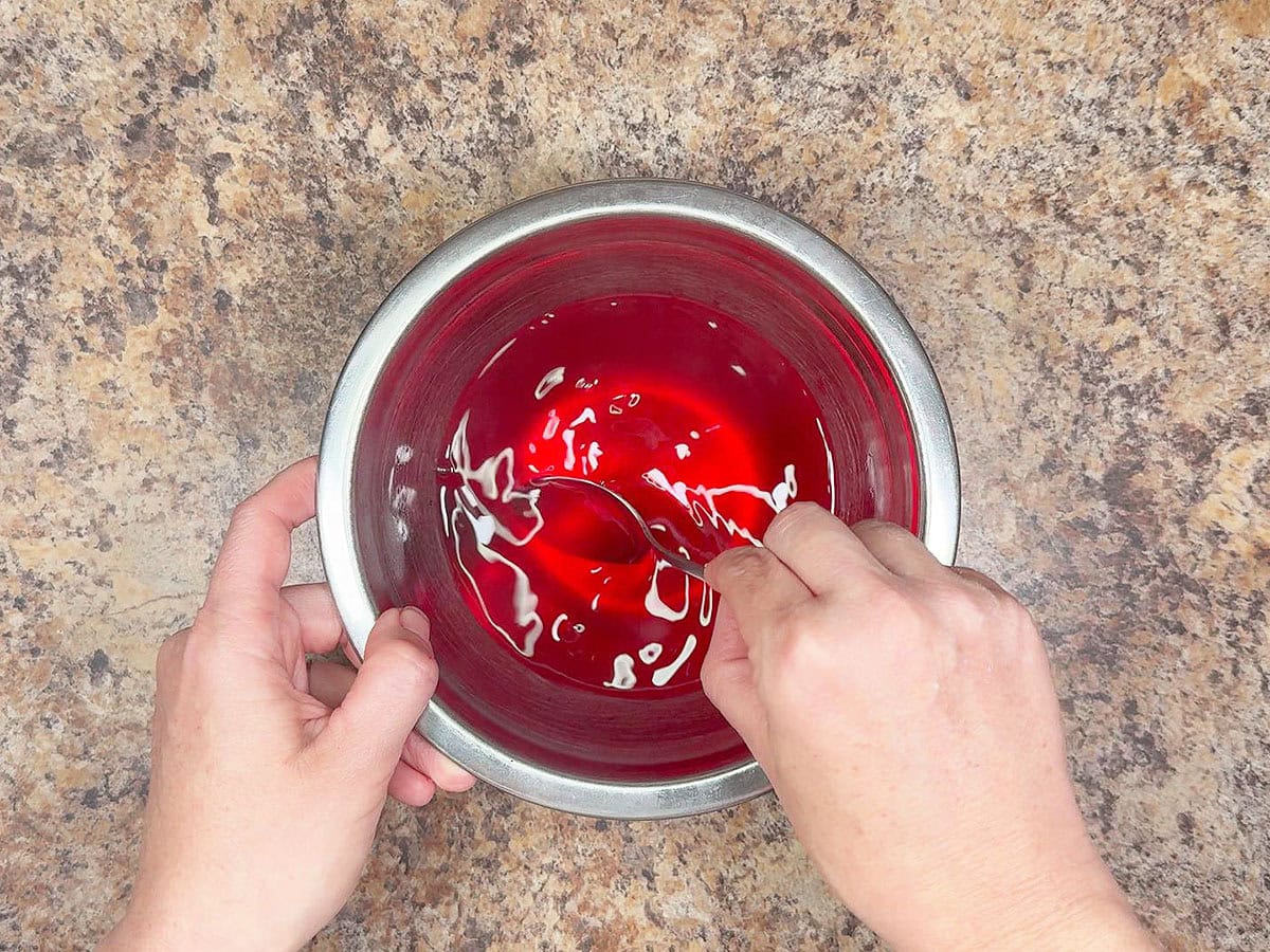 Dissolving the strawberry gelatin in hot water.