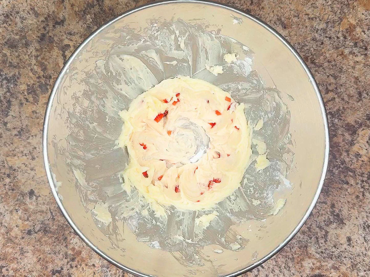 Strawberry icing after one cup of sugar and one tablespoon of strawberries have been added.