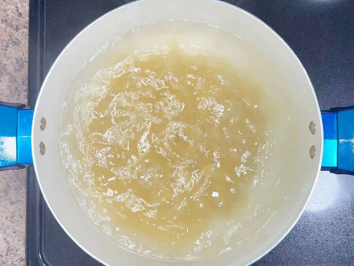 Boiling the macaroni pasta in a large pot of salted water until al dente.