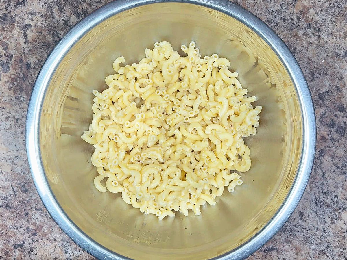 Cooked macaroni noodles in a large mixing bowl.