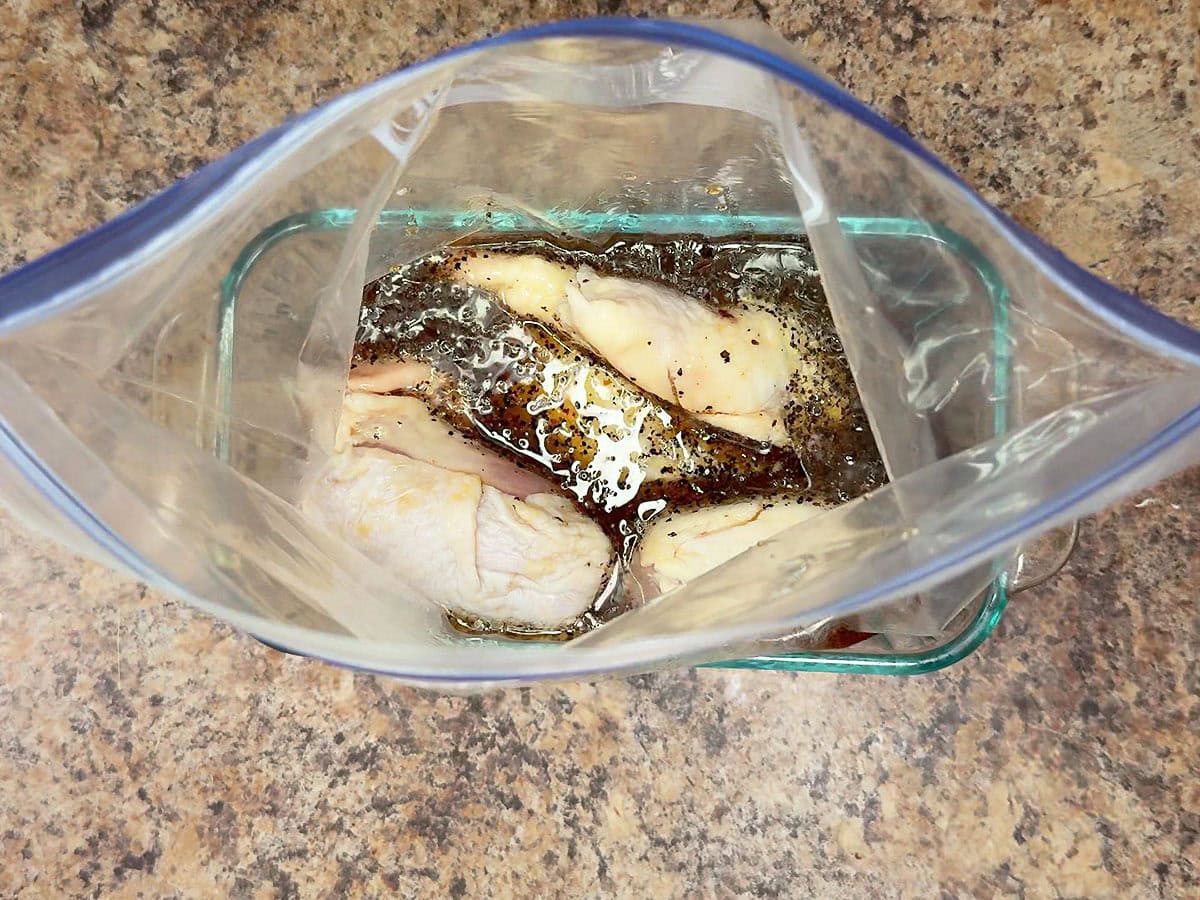 Chicken thighs in a plastic freezer bag with the apple cider vinegar chicken marinade poured over the top.
