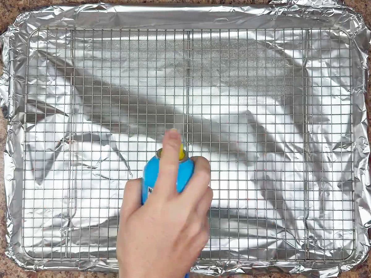 Lightly coating a baking rack with cooking spray.