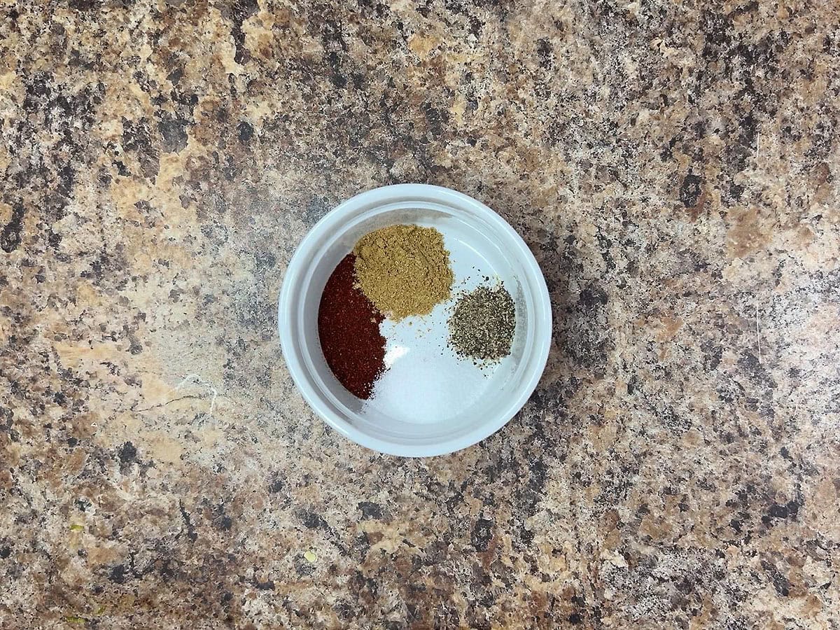 Chili powder, cumin, salt and ground black pepper in a small bowl.