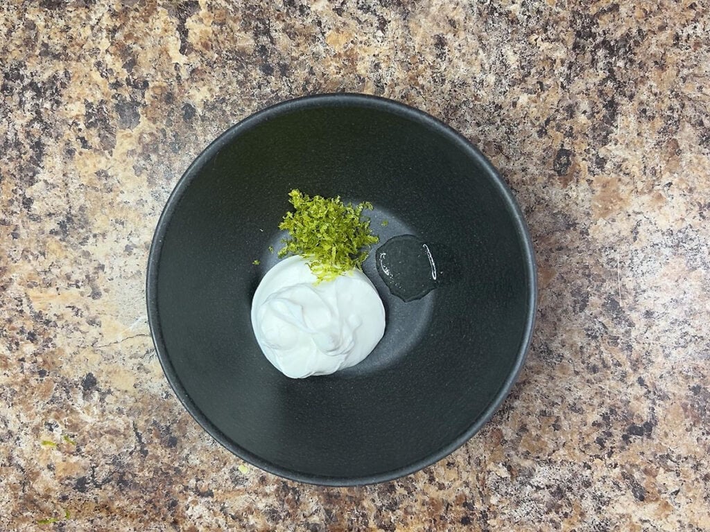 Sour cream, zested lime peel and lime juice in a small mixing bowl.