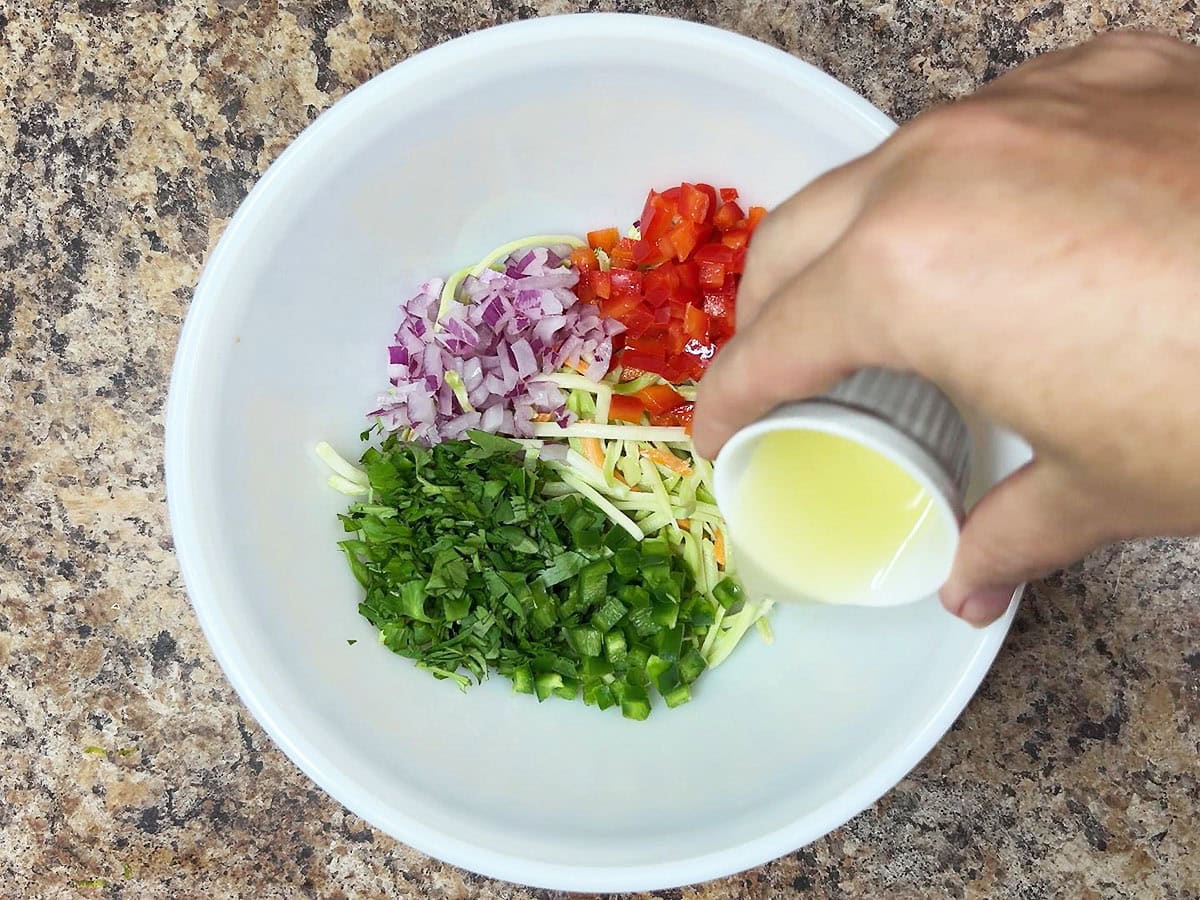 Adding fresh lime juice to the slaw ingredients.