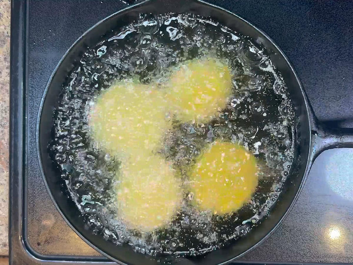 Frying the breaded green tomatoes in hot oil.