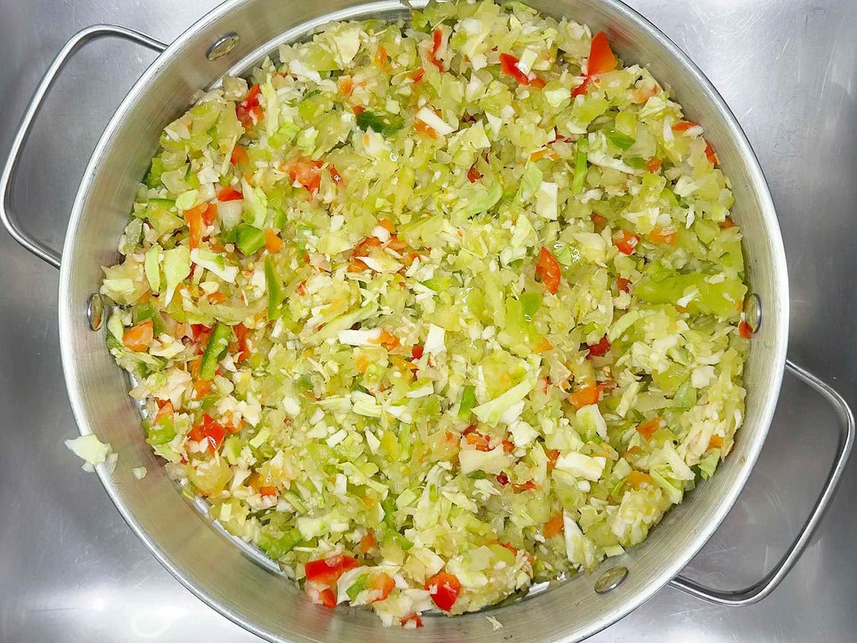 Salted chopped vegetables in a metal colander.