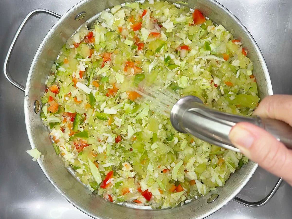 Lightly rinsing the salted vegetables in a colnader.